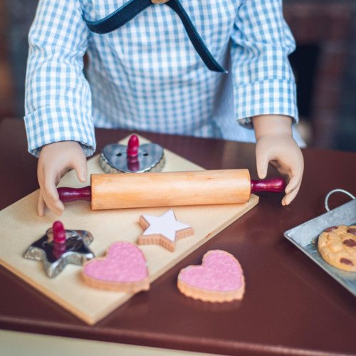 In 18 inch doll kitchen on our farmhouse table, a doll holds the rolling pin over a wooden breadboard, with the 2 cookie cutters and 4 each of star and heart shaped sugar cookies. In 18 inch doll kitchen on our farmhouse table, a doll holds the rolling pin over a wooden breadboard, with the 2 cookie cutters and 4 each of star and heart shaped sugar cookies.