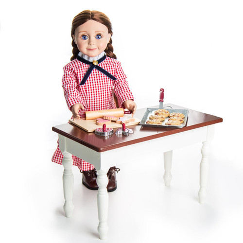 Against white backdrop our 18 inch Little House on the Prairie Laura doll stands next to  18 inch table with the 16 Piece Cookie Baking and Tool Set. Against white backdrop our 18 inch Little House on the Prairie Laura doll stands next to  18 inch table with the 16 Piece Cookie Baking and Tool Set.