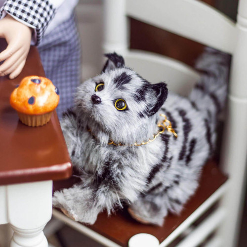 In 18 inch doll kitchen the grey striped kitty cat 18 inch doll accessory sits on the table chair.