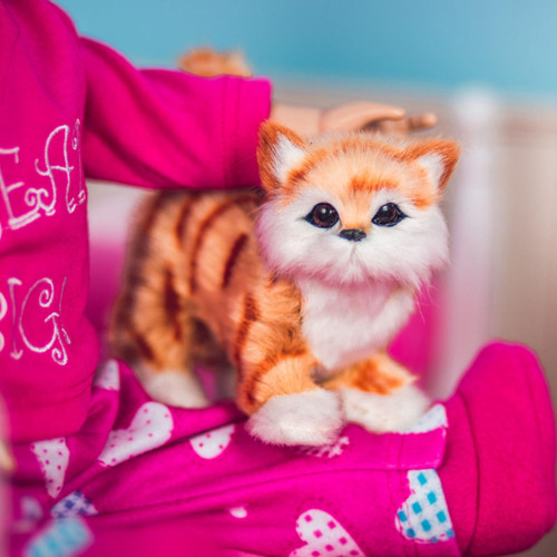 In indoor scene the orange tabby 18" accessory cat sits next to an 18" doll. In indoor scene the orange tabby 18" accessory cat sits next to an 18" doll.