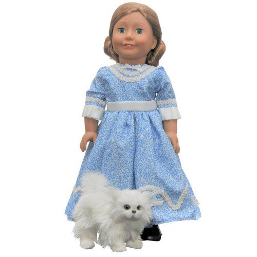 Against white background an 18 inch doll wears the blue Sunday dress compatible with American Girl dolls produced after 2008. The white 18 inch doll cat stands below her.