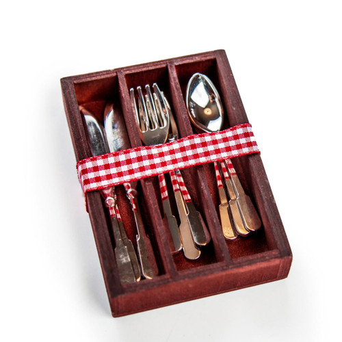 The silverware nest neatly in each of their sections in the wooden holder tied close with a red checked ribbon. The silverware nest neatly in each of their sections in the wooden holder tied close with a red checked ribbon.