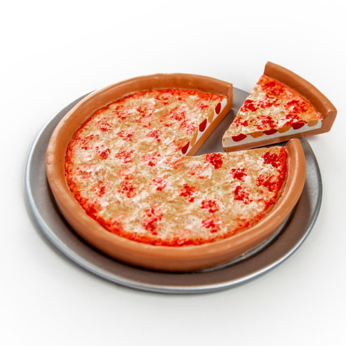 A high-angle studio shot features a doll-sized toy cheese pizza resting on a round silver metal pan against a solid white background. The realistic toy pizza has a thick, tan crust with melted cheese, with one individual slice completely removed and placed adjacent to the open gap.