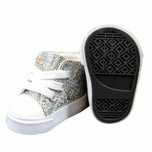 A pair of silver glitter doll shoes by The Queen’s Treasures® that fits 18in American Girl® Dolls. The left shoe is a high-top sneaker with white laces and a white toe cap, shown from a front-angle view. The right shoe is turned upside down next to it, displaying the detailed black rubber sole with geometric tread patterns.