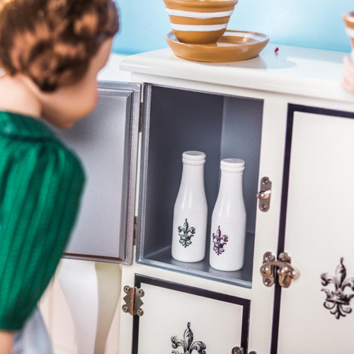 In kitchen play scene, an 18 inch doll has opened a door of our 1930s white icebox to take out one bottle of milk. In kitchen play scene, an 18 inch doll has opened a door of our 1930s white icebox to take out one bottle of milk.