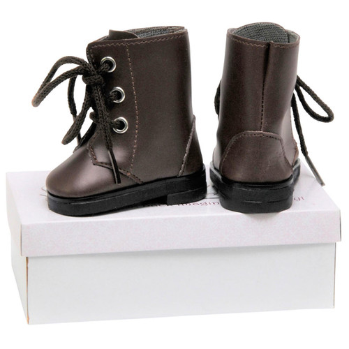 A pair of miniature dark brown doll boots rests on top of a rectangular white shoe box against a plain white background. The boot on the left is shown from a side profile view, highlighting three silver eyelets with thick brown laces tied in a bow. The boot on the right is turned backwards, displaying the heel panel and rear stitching details.