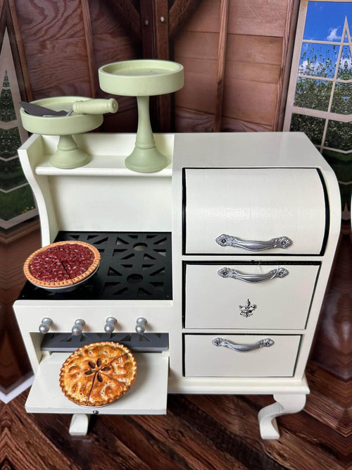 In doll kitchen setting, our 1930s white oven stove for 18 inch dolls has the apple pie coming freshly out of the oven and the pecan pie resting on the cooktop. The two pie stands are stored on the oven's shelf above. In doll kitchen setting, our 1930s white oven stove for 18 inch dolls has the apple pie coming freshly out of the oven and the pecan pie resting on the cooktop. The two pie stands are stored on the oven's shelf above.