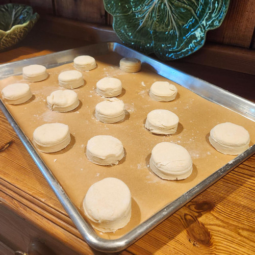 Biscuit dough shown on sheet pan covered with parchment paper. Biscuit dough shown on sheet pan covered with parchment paper.