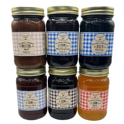 Six jars of Caroline's Kitchen fruit spreads arranged in two stacked rows, featuring flavors like Apple Butter, Black Raspberry Jam, Elderberry Jelly, and Damson Plum Jam, each with a distinctive gingham pattern label against a solid white background.