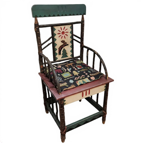 The image shows a rustic, hand-painted wooden armchair featuring twig-style accents, a deer and sun motif on the back panel, and a patterned fabric seat cushion. Tilted toward the right.