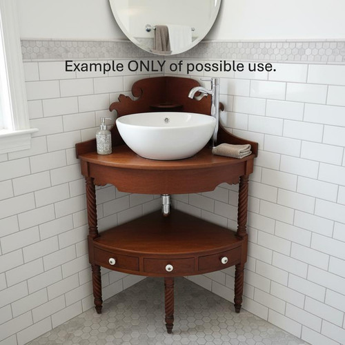 An antique wooden corner washstand repurposed as a modern bathroom vanity, fitted with a large white ceramic vessel sink, a chrome faucet, and a soap dispenser in a tiled bathroom corner.