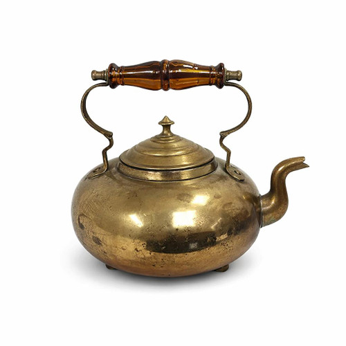 An antique brass toddy kettle isolated on a white background, featuring a stepped lid, a curved swan-neck spout, and a decorative translucent amber handle.