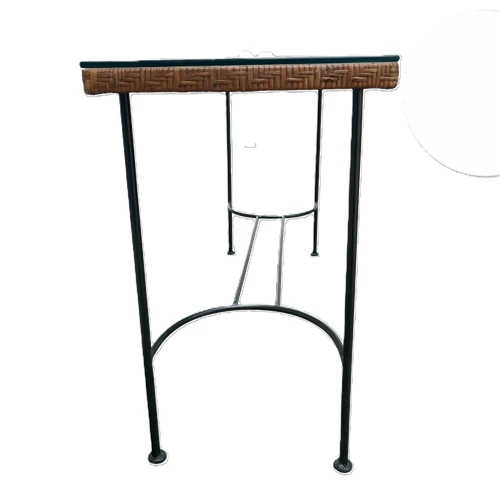Side profile of narrow wrought iron console table highlighting woven reed tabletop edge and arched iron lower stretcher