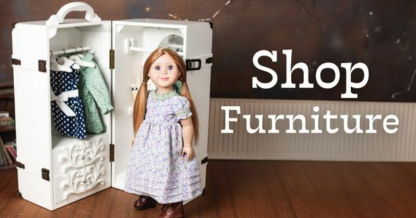 Shop Furniture; Image of the White wooden Trunk willed with clothes and an 18 inch doll standing in front. 