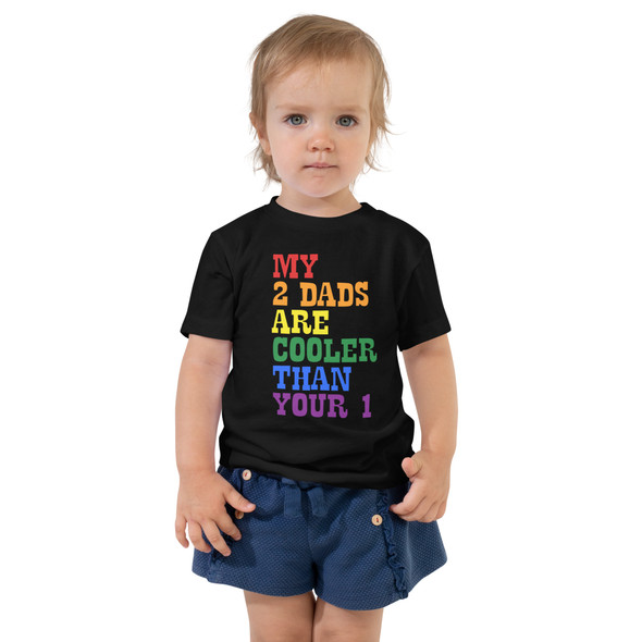 Model wearing Toddler shirt with bold rainbow text that reads "My 2 Dads Are Cooler Than Your 1," perfect for pride and playful family moments. Model wearing Toddler shirt with bold rainbow text that reads "My 2 Dads Are Cooler Than Your 1," perfect for pride and playful family moments.