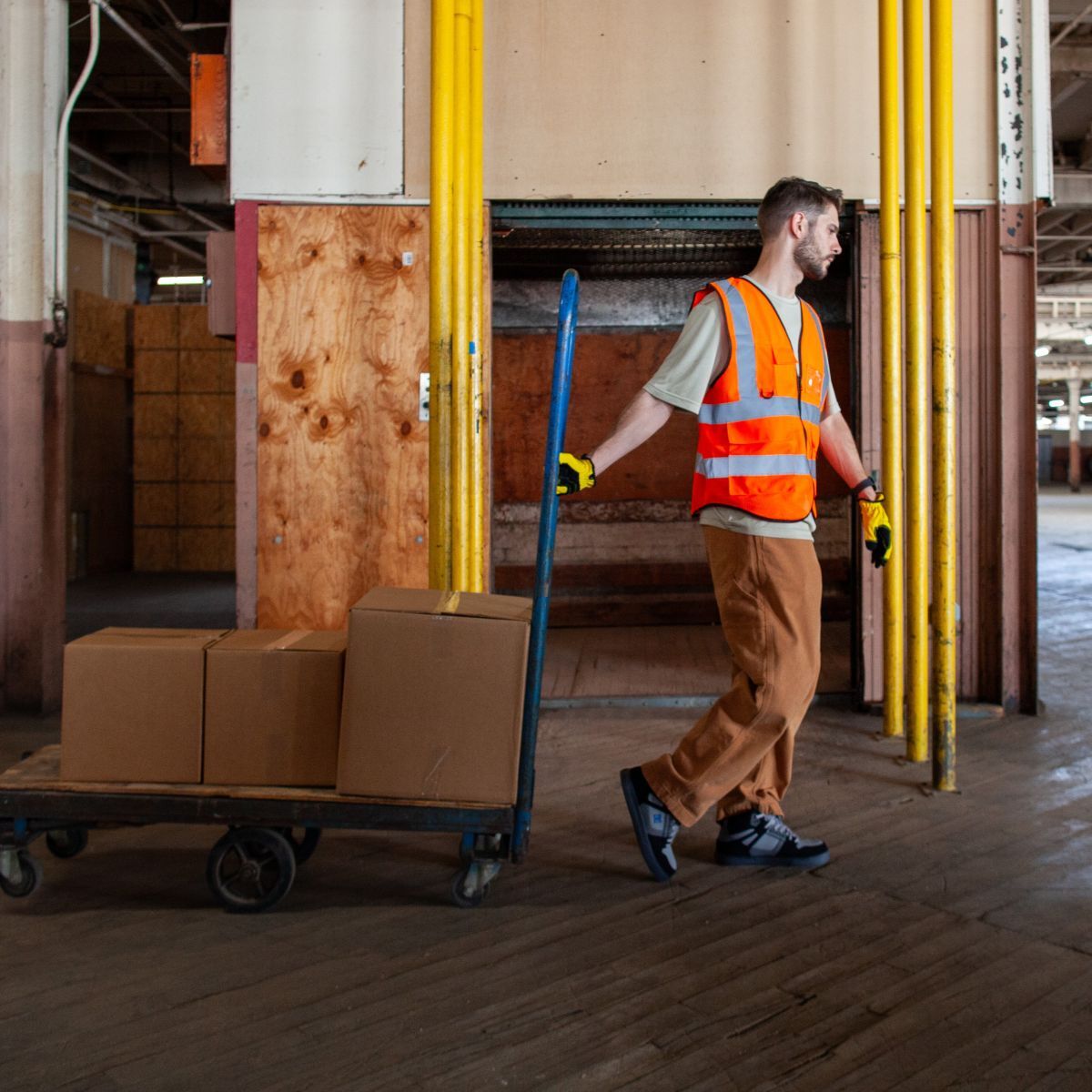 Warehouse worker pulling a trolly with boxes wearing shoes in style DC60205