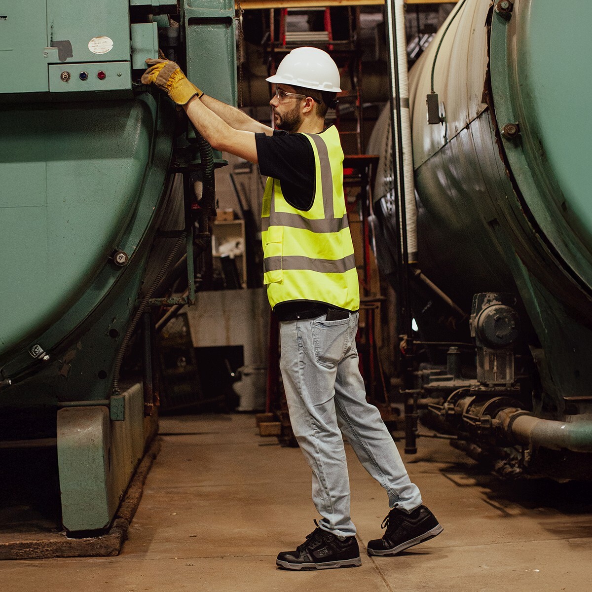 Worker in a factory working on an electrical panel wearing DC electrical hazard shoes