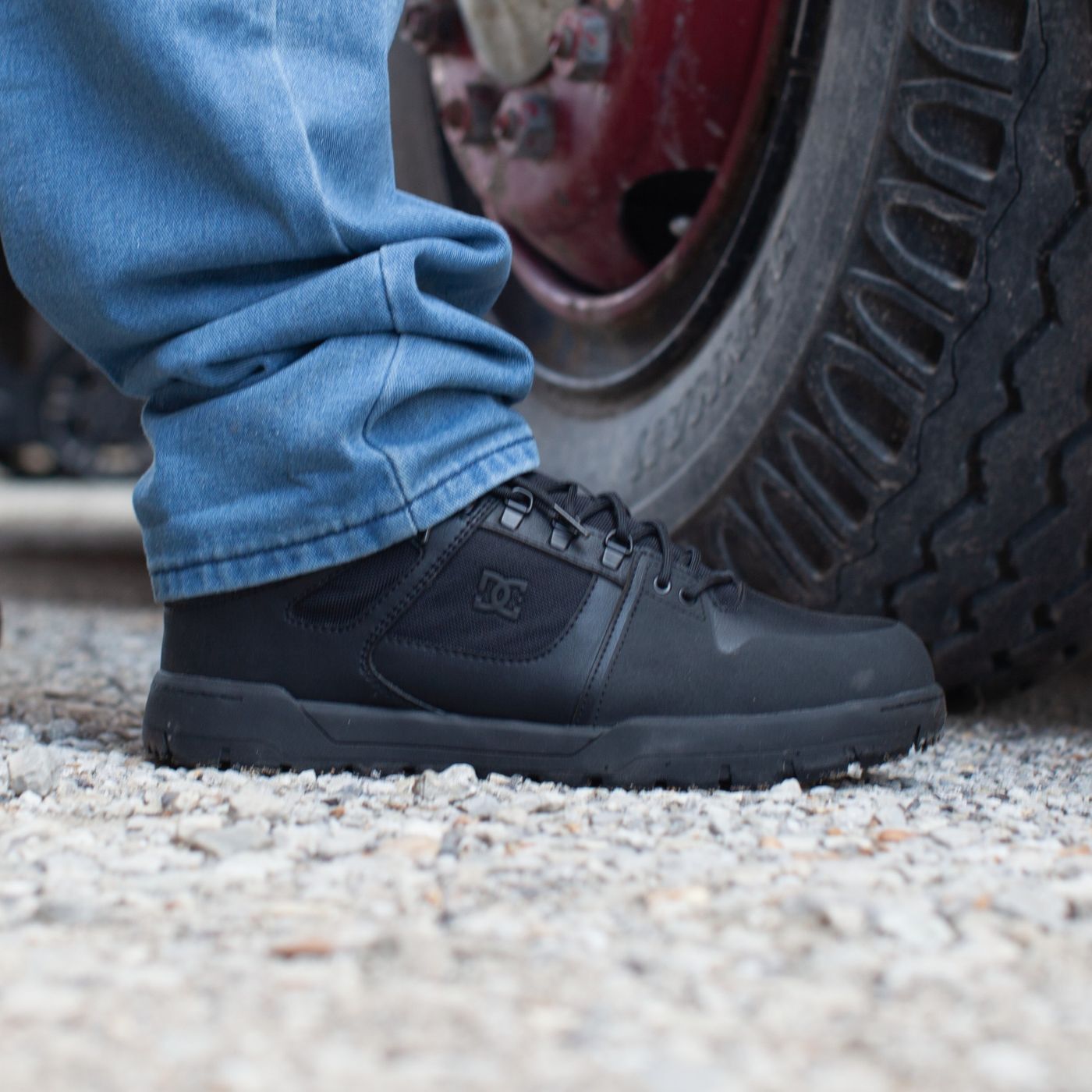 dc60604-dc-img-1761-square-1400.jpg Closeup of worker wearing DC Work Crew met guard shoe with gravel and tire in the frame