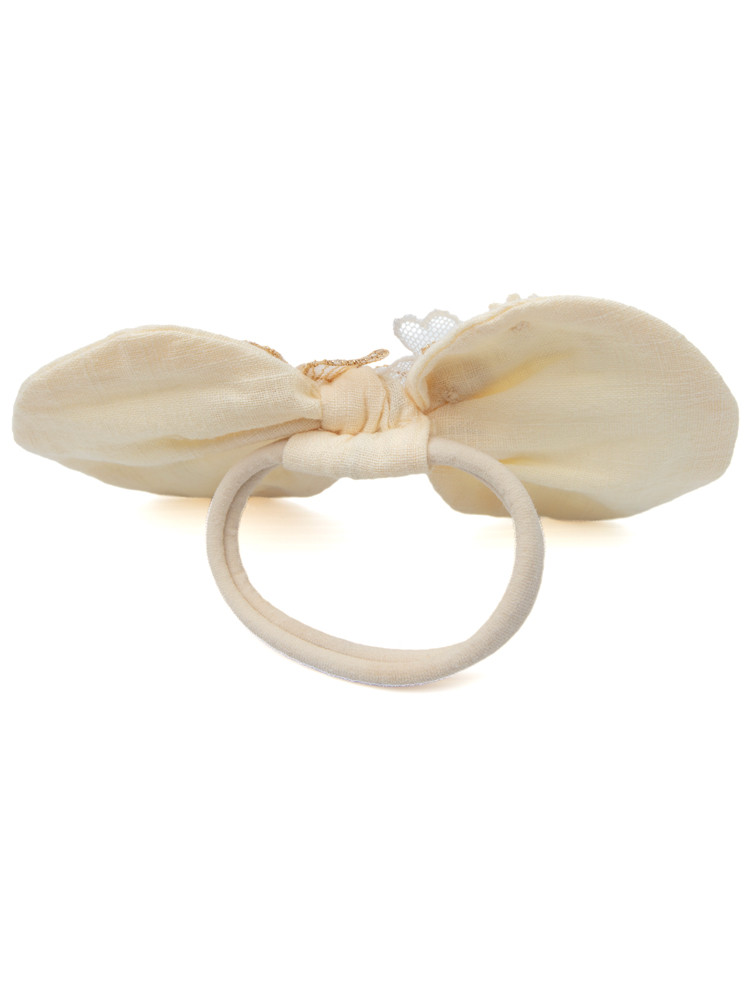 Back of handmade ivory bow showing soft hair elastic