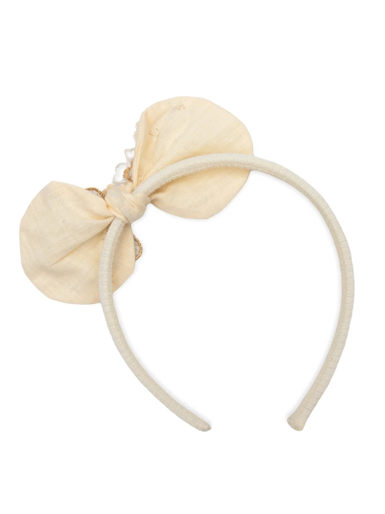 Back of handmade ivory bow showing fabric-covered headband