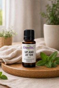 Bottle of Up and At 'Em™ essential oil blend featuring Nutmeg, Sage, German Chamomile, Geranium, and Spearmint in fractionated coconut oil for natural daily energy and motivation support.