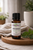 Essential7 Patchouli Essential Oil bottle (15ml) with Pogostemon cablin botanical name on label, displayed on a wooden tray with soft natural light and neutral linen background.