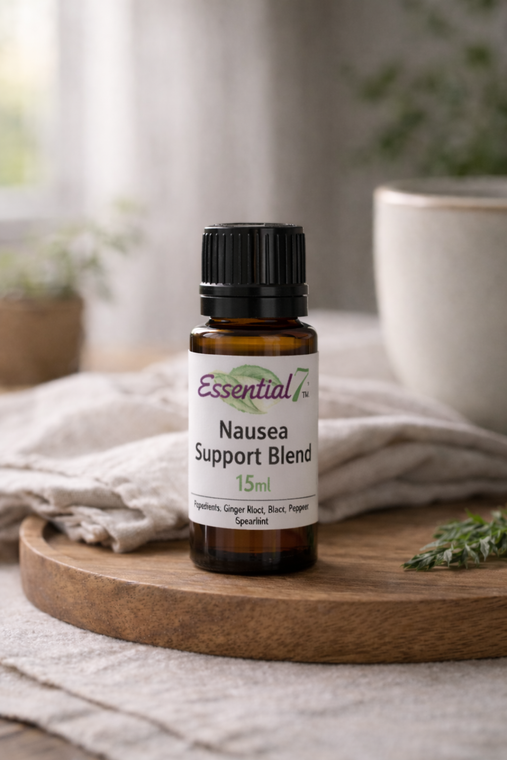 Essential7 Nausea Support Blend essential oil in a 15ml amber glass bottle with peppermint, black pepper, and spearmint, styled on a wooden tray in soft natural light to reflect a calm digestive support routine.