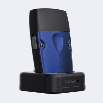 Rear view of the BaBylissPRO® LO-PROFX Compact Foil Shaver docked in its black charging stand, highlighting the blue metal housing and ergonomic grip.