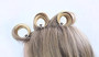 Duckbill clips securing pin curls or roller sets in blonde hair. Demonstrates the clips' use in setting waves and securing volume.