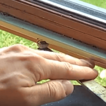 Image showing downward pressure applied to roller arm to disconnect roller arm from guide channel track | OGS - Ontario Glazing Supplies