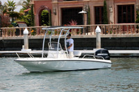 Side view of SG600 folding boat t-top model made with 6061-T6 Aluminum in anodized finish with black canopy installed on a boat in the water.