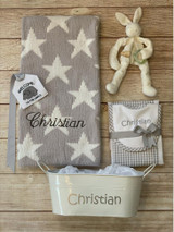 Chenille baby blanket gift by Wicked Stitches Gifts. Shown is the gray stars style with coordinated bib and burp set, cuddle bud pacifier holder, gift tin and tag. Add any of these extras to make the gift totally unique.