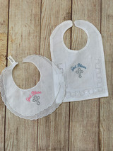 Fine cotton linen Christening Bib.  Choose pink or blue embroidery for "God Bless".  Cross is always silver.
Wicked Stitches Gifts.