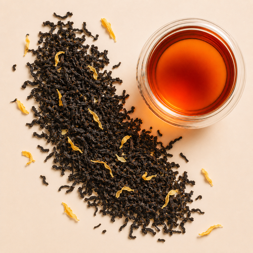 Bourbon Black Tea loose leaf blend with black tea, golden sunflower petals, calendula petals, and a cup of amber brewed tea.