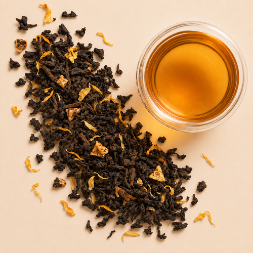 Peach Oolong loose leaf tea with oolong leaves, golden marigold petals, peach pieces, and a cup of amber brewed tea.