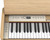 Roland F-701 Digital Piano in Light Oak finish with matching padded bench, full 88-key keyboard, and modern slimline cabinet design.
