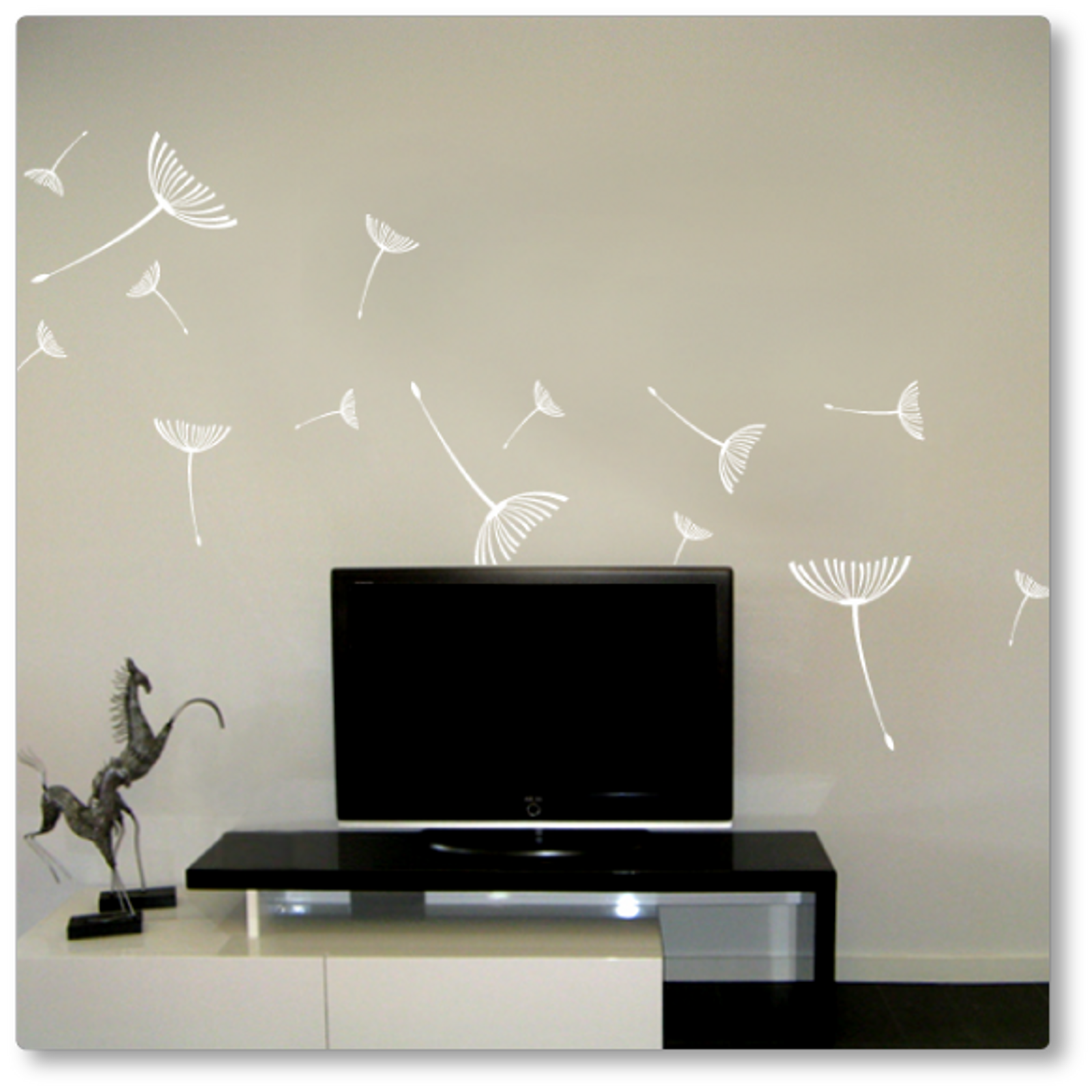 The dandelion seeds flying away decal has fifteen seeds of varying sizes flying away. Shown here in white on a beige wall.