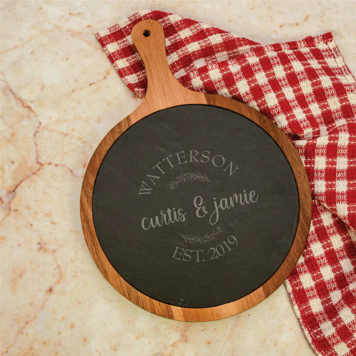 Round Acacia wood and slate cutting board with handle is personalized with couple's first names, last name and established year