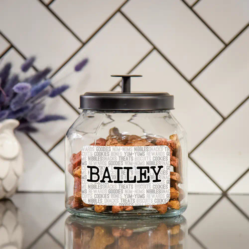 Personalized glass dog treat jar has pet's name printed on a label along with various words for dog treats