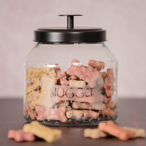 Engraved dog treat jar features pet's name  inside of bone with graphics engraved around the jar.