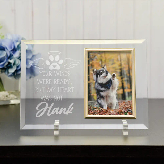 Personalized glass pet memorial picture frame with two easel legs, engraved with a pet's name, featuring the sentiment "Your Wings Were Ready, but my heart was not" holding a 4x6 photo, displayed on a tabletop as a sympathy keepsake gift.