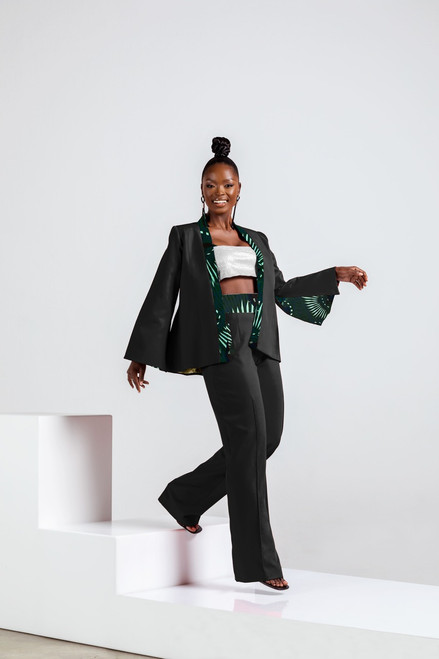 Model wearing Pump Suit Ensemble - black blazer and pants with green African wax print