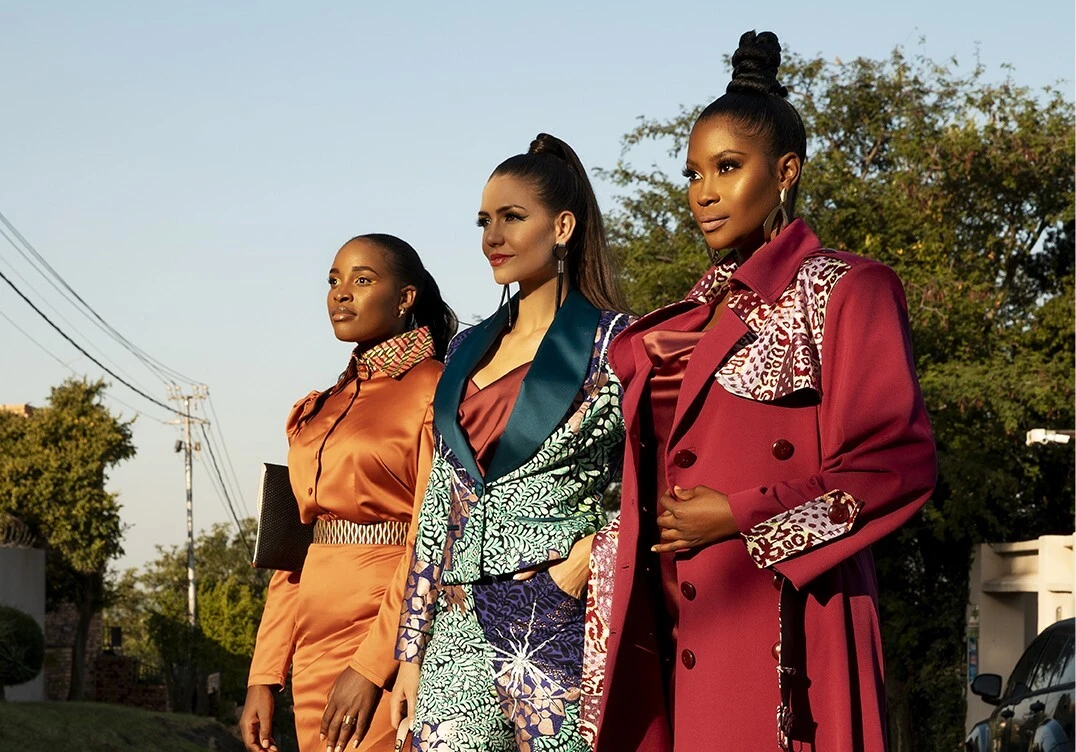 Three women in Laud Pulse outerwear outdoors at golden hour