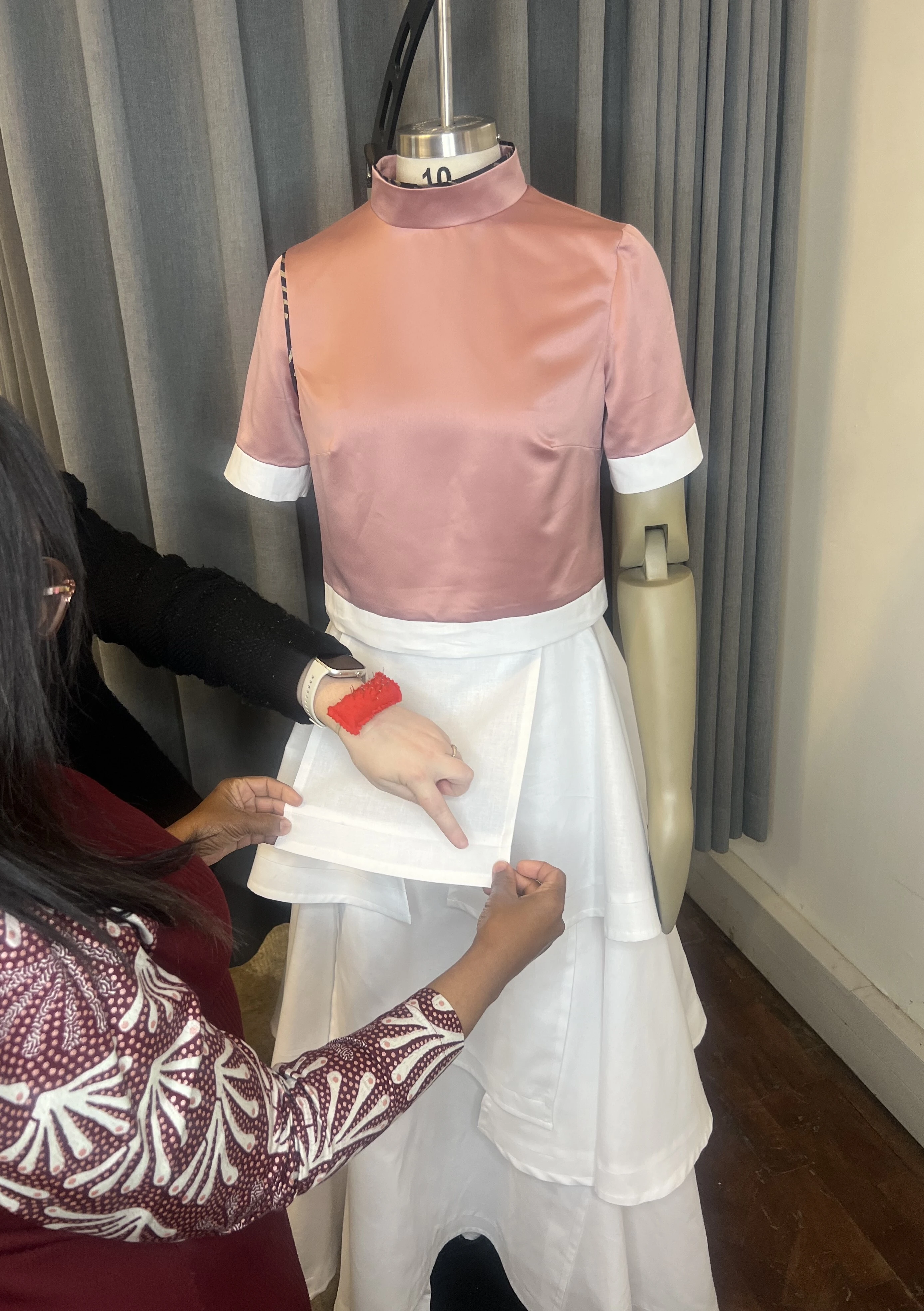 Seamstress working on a garment on a dress form