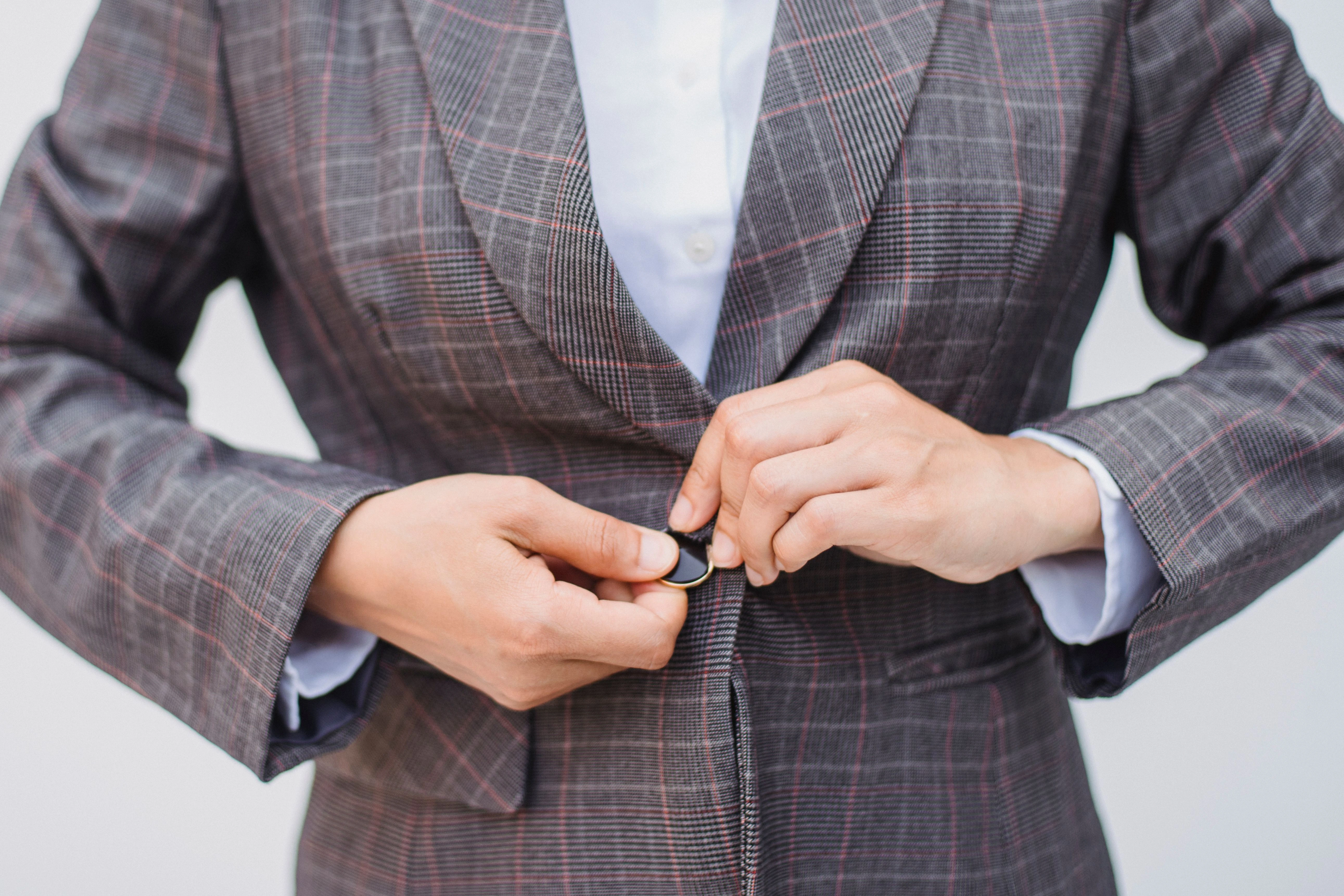Woman buttoning a tailored blazer