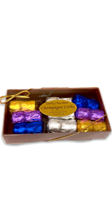 rectangular box with clear lid displaying 6 multi- color, foil wrapped chocolates
