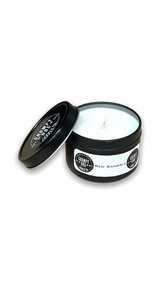 round black metal tin with lid containing white candle wax

