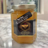 hexagonal jar with a gold lid, containing golden honey. black label with a gold border and gold bee. a black banner reading "New Times Best Local Honey Winner 2022"