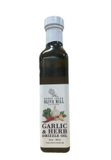 Rectangular glass bottle with a white label portraying garlic cloves, herbs and peppers and the words "Garlic & Herb Drizzle Oil".
