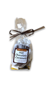 Clear cello bag with individually wrapped caramel pieces inside with a brown bow and a square logo on front.